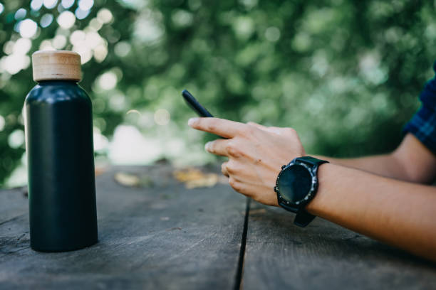 istock Young woman connects with the world, using her mobile phone while seated in the serene forest 1646429466