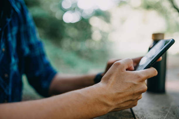 istock Young woman embraces a digital break in the forest, using her mobile phone while enjoying nature's tranquility 1646429484