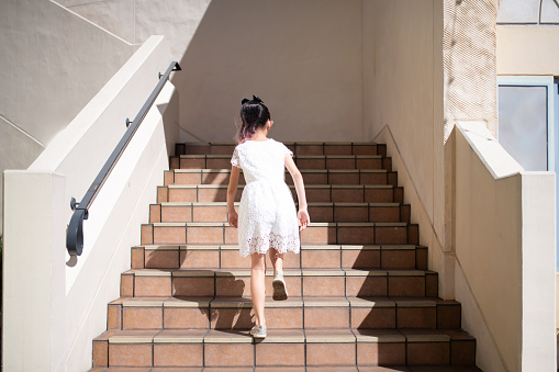 Rear view of a girl climbing the stairs