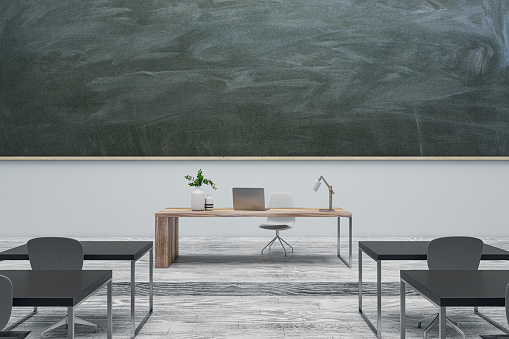Contemporary gray classroom interior with chalkboard, furniture and wooden flooring. Mock up place. Back to school concept. 3D Rendering