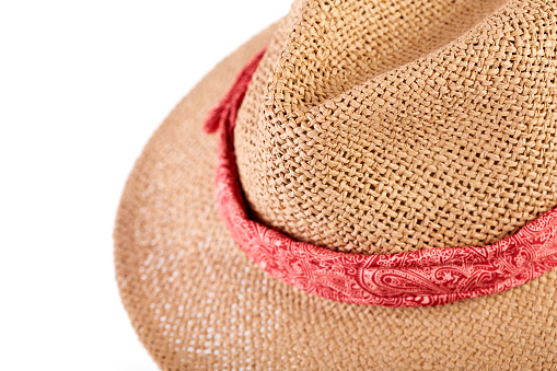 Wicker straw flaxen hat with red ribbon on isolated white background. Fashion accessory. Female summer hat.