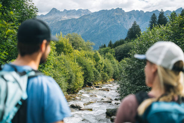They are standing on a bridge looking upstream in forest