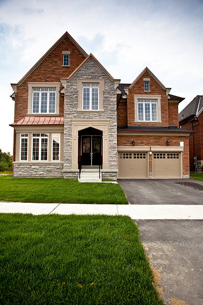 istock Brick and stone home with double garage and pointed rooftops 164644054