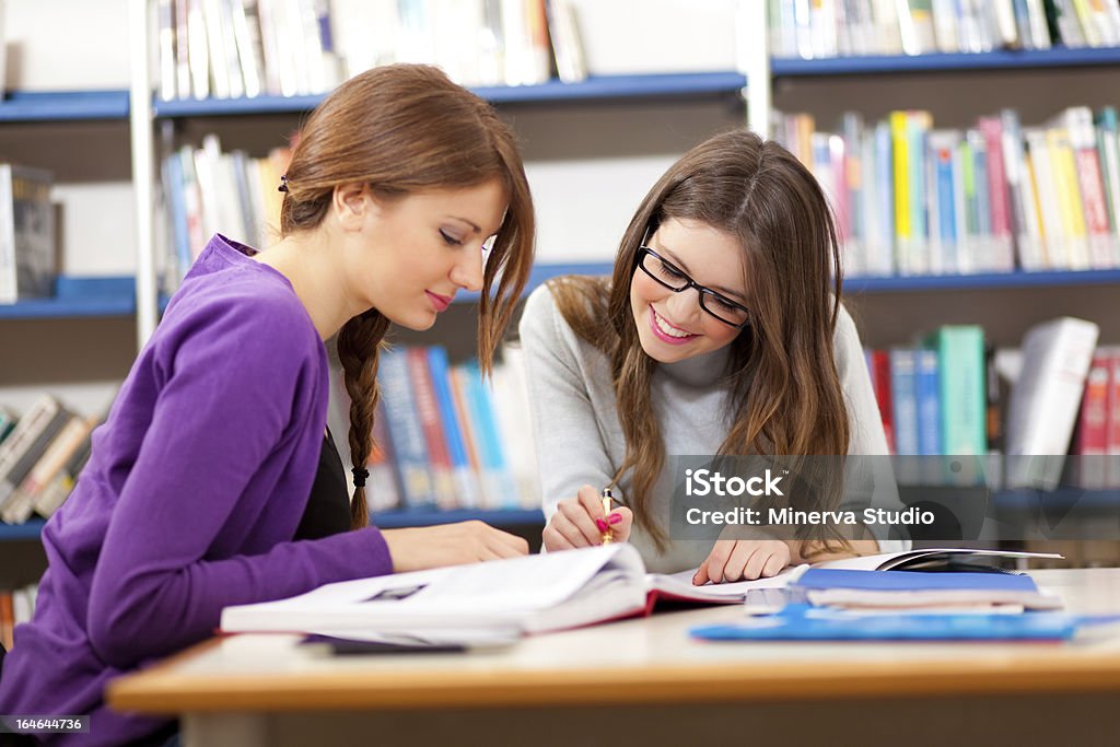 Two female students in a library People studying in a library Adult Stock Photo