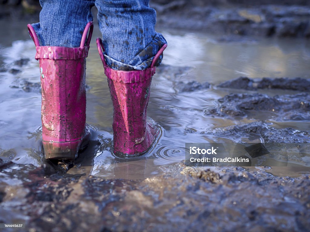 Boots splashing in puddle Boots splashing in mud puddle Boot Stock Photo