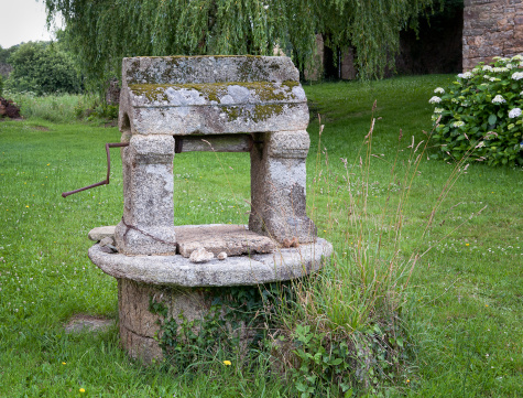 Typical antique fountain in Brittany.  Hydrangea flowers in the background are also typical for the region.