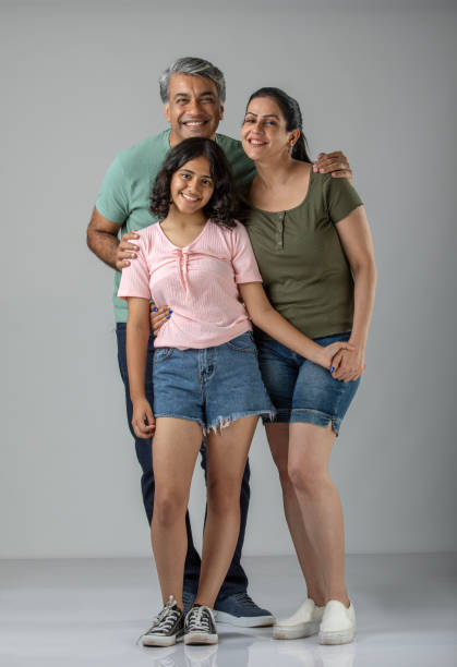 istock Loving parents embracing daughter over white background 1646459714