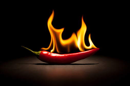 Photography of a red chili pepper on fire.