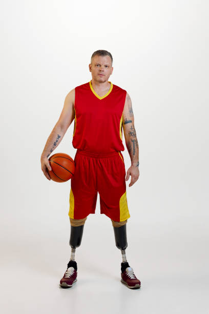 istock Attractive young man amputee with prosthetic leg disability standing holding orange basketball ball. Inclusive sport for people with disabilities. 1646463270