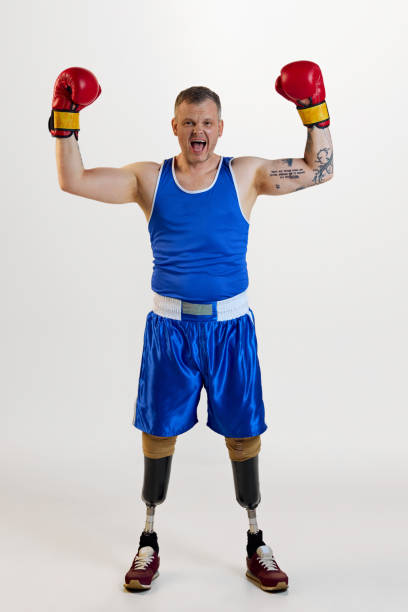 istock Full length of attractive confident man with prosthesis in boxing uniform shouting with raising hands and enjoying his hobby. 1646463279