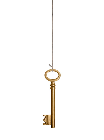 Gold key, hanging on a string. Isolated on white.