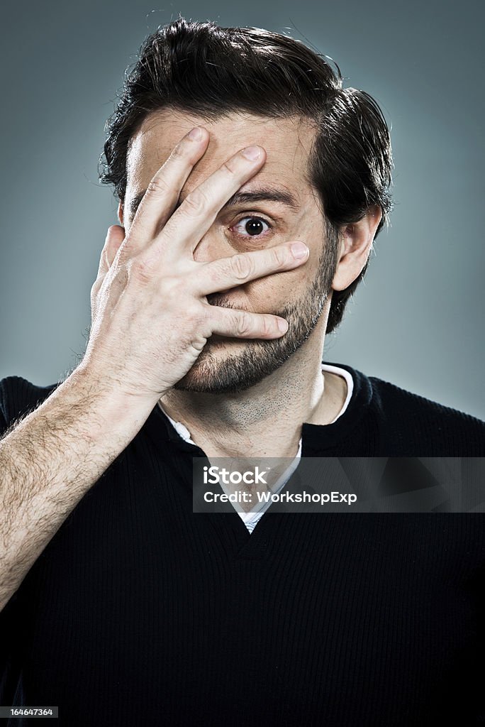 Paura uomo con una mano al suo viso - Foto stock royalty-free di Abbigliamento casual