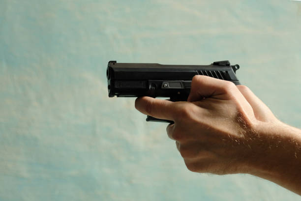 istock Men's hands hold the gun off hand. 1646478918