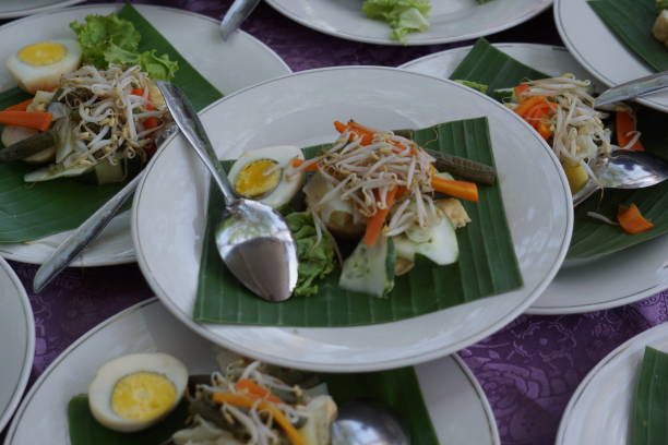 Gado-gado is a typical Indonesian food containing boiled vegetables, sliced eggs and tofu, sprinkled with fried onions and crackers and served with peanut sauce.