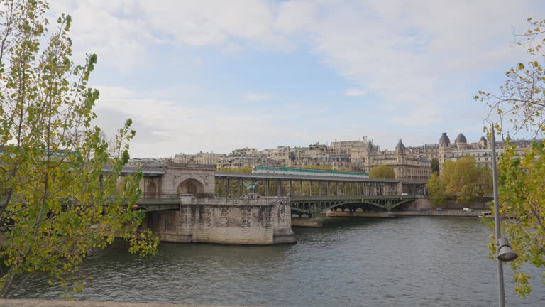 Urban view of Paris city metro train passing over the Seine river in autumn.