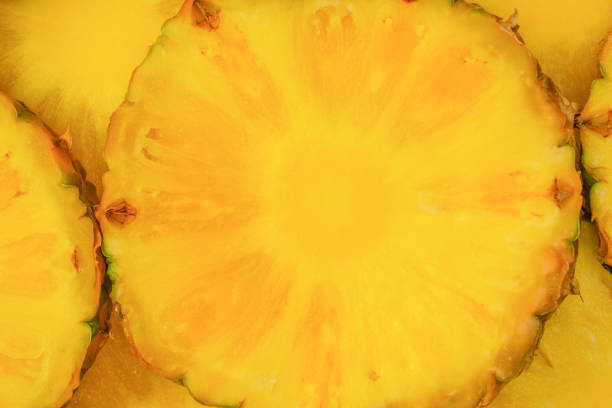 Pineapple juicy yellow slices as a background. Top view.
