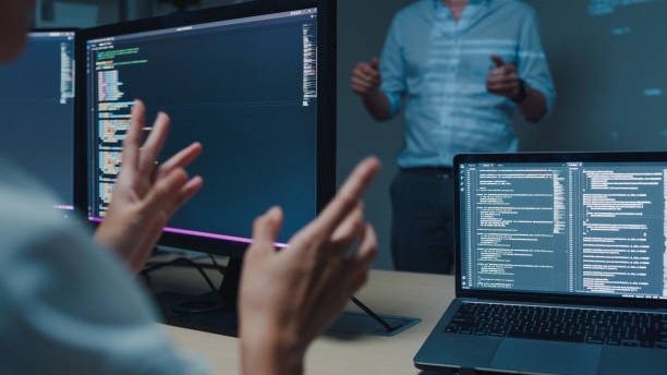 Closeup young Asian man software developers mentor leader manager talking to executive team analyzing source code in office at night. Programmer development. Closeup young Asian man software developers mentor leader manager talking to executive team analyzing source code in office at night. Programmer development concept. javascript stock pictures, royalty-free photos & images