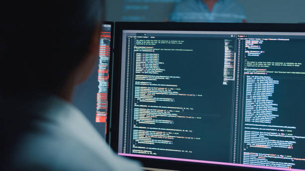 istock Closeup young Asian man software developers mentor leader manager talking to executive team analyzing source code in office at night. Programmer development. 1646501665