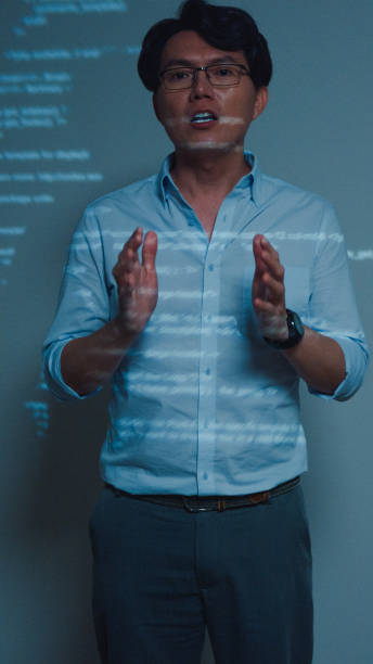 istock Closeup young Asian man software developers mentor leader manager talking to executive team analyzing source code in office at night. Programmer development. Vertical Screen. 1646501670