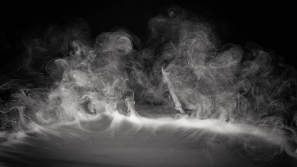 Smoke, fog or steam on black background flowing or rolling from center to edges stock photo