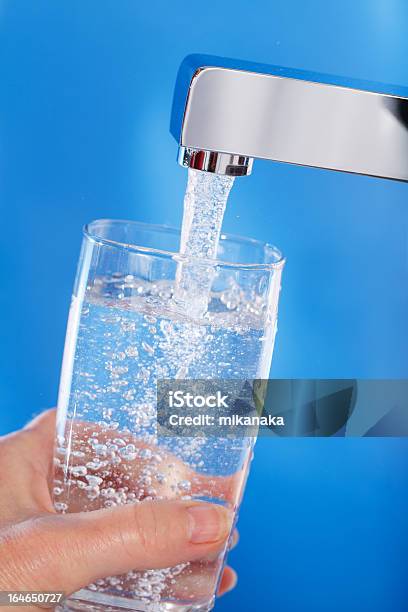 Llenar Un Vaso De Agua Fondo Azul Foto de stock y más banco de imágenes de Agua del grifo - Agua del grifo, Grifo - Herramientas profesionales, Vaso