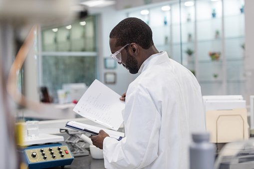 The young adult male scientist works in the laboratory of a nutritional supplement company.