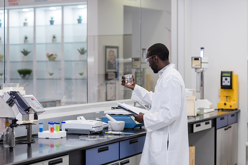 The young adult male tech conducts many experiments in his work for a nutritional wellness company.