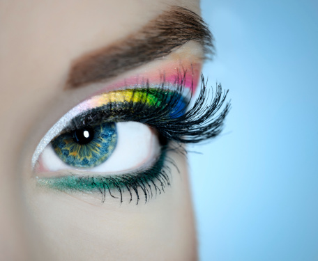 young woman blue eye with colorful makeup.