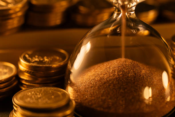 istock The time is money. Hourglass and coins. 1646523810