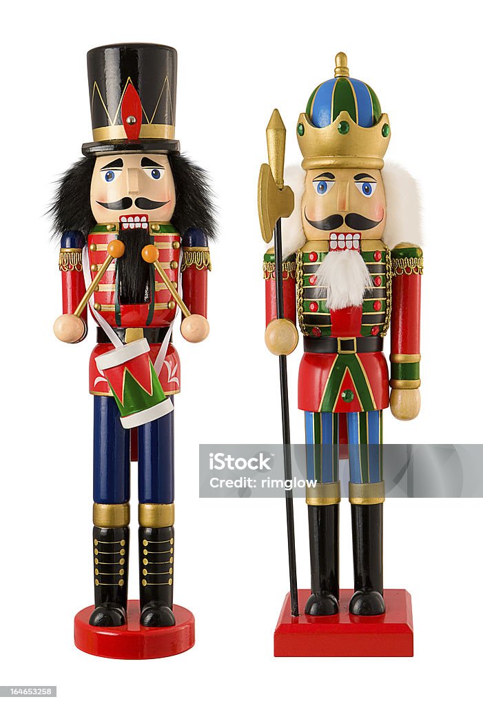 Two Wooden Christmas Nutcrackers Isolated Two wooden Christmas Nutcrackers standing side by side. One  nutcracker is a drummer.  One figurine has black hair, and the other figurine has white hair.  Nutcrackers are used to crack open nuts, but can also be used as colorful Christmas decorations. The image is isolated on a white background. Nutcracker Stock Photo