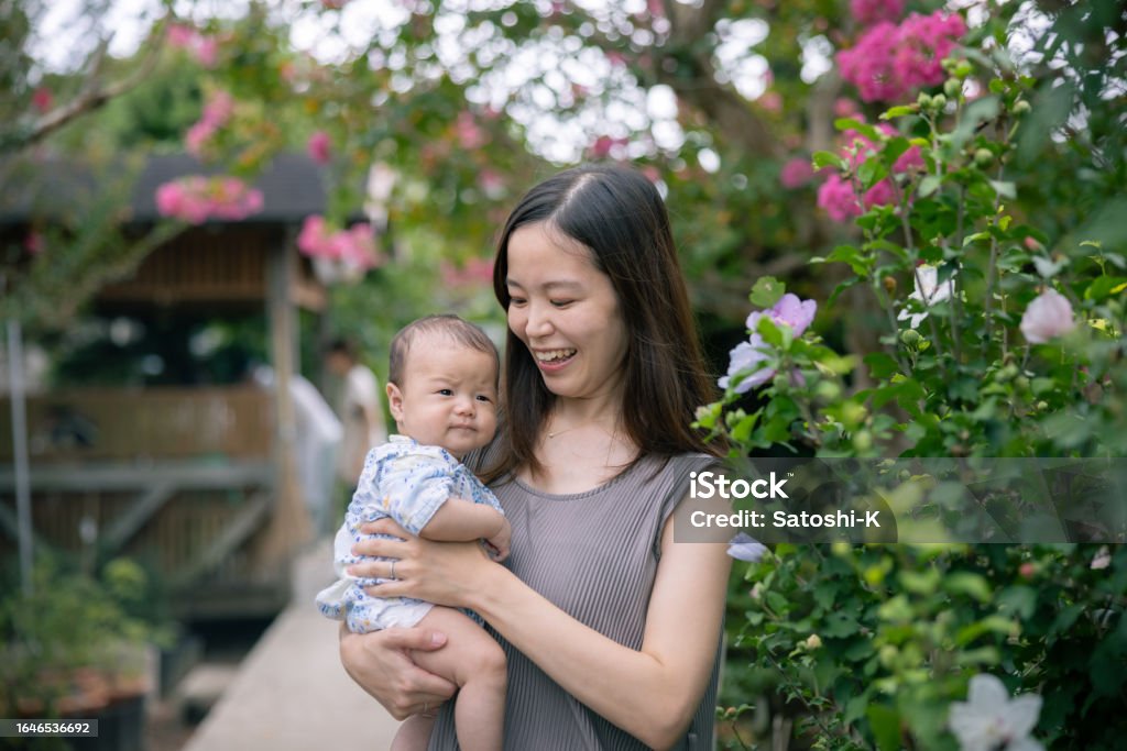 Portrait of mother and her baby standing nearby hibiscus flower Chiba Prefecture Stock Photo