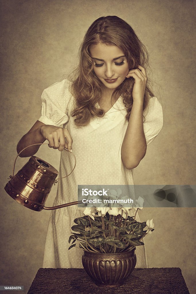 Giovane donna vatering fiori in vaso - Foto stock royalty-free di 20-24 anni