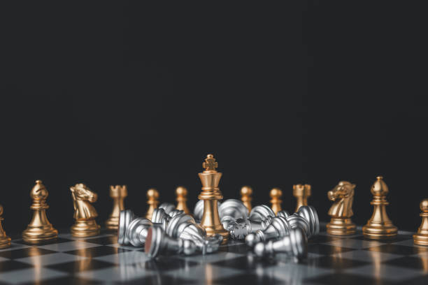 istock Golden chess king stands among the falling silver chess pieces for the winners and defeats after the match. business strategy concept. 1646554682