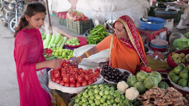 Young Indian woman buying fresh vegetables in Jaipur, India