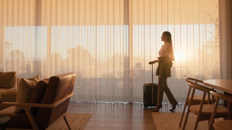 Travel, suitcase and a business woman walking in an airport lounge for departure on an international flight. Luggage, morning flare and a female employee leaving a hotel and ready for boarding