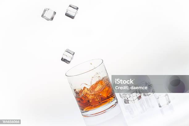 Whisky Sulle Rocce Schizzati Da Cubi Cubetti Di Ghiaccio - Fotografie stock e altre immagini di Versare