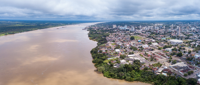 Aerial drone view of Porto Velho city center skyline, streets, squares and Madeira river. Amazon rainforest in the background on cloudy summer day. Rondonia state, Brazil.