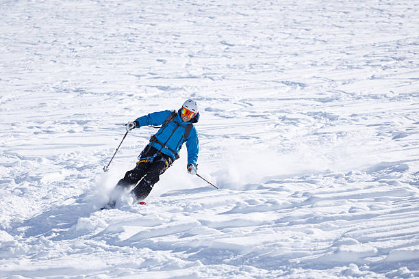 Skier making big carving turn in powder snow stock photo