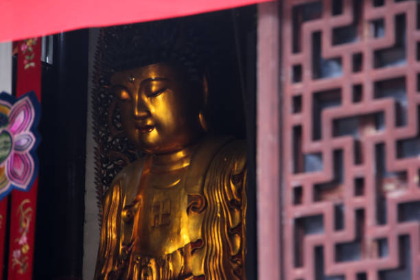 Shanghai, China - October 05, 2016 - A large and golden sitting Buddha statue in Jade Buddha Temple