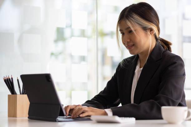 istock Asian businesswoman working with modern tablet in office. 1646568896