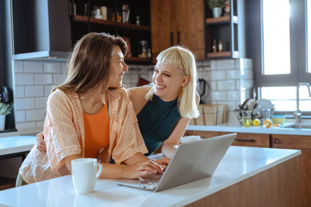 istock Beautiful lesbian couple using laptop at home 1646578901