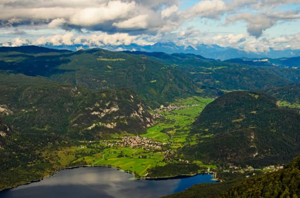 scenic aerial panoramic view of bohinj lake with mountain range and valley with small village. nature landscape during the autumn season. travel and tourism concept. triglav national park, slovenia - julian alps mountain lake reflection imagens e fotografias de stock