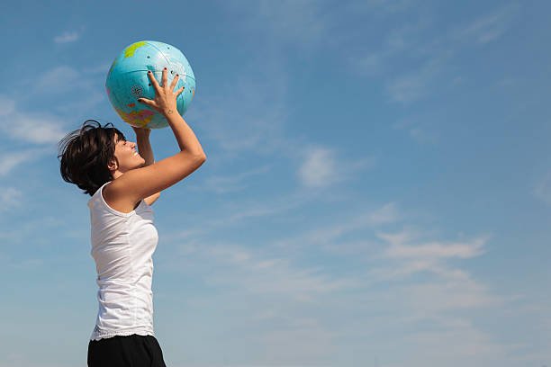 Cheerful Young Woman with World Globe stock photo