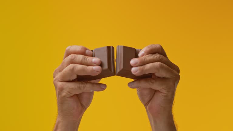 SLO MO LD Male hands breaking apart a thick chocolate bar