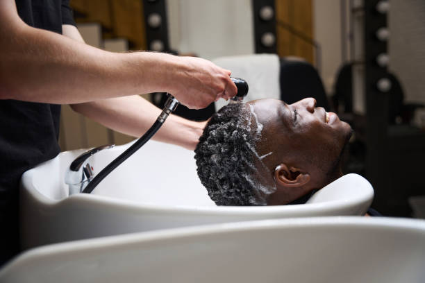 istock Man washes off foam from clients hair with warm water 1646611180