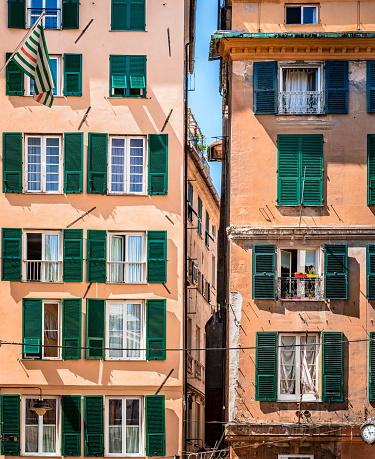 Facades of two similar residential building in Genoa downtown, Italy. A renovated one on the left and an old one on the right.