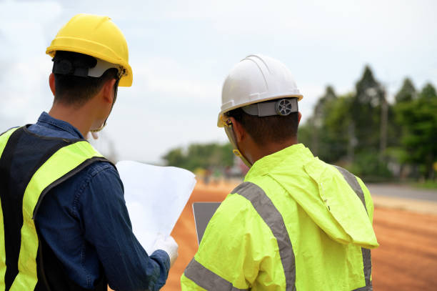istock Asian Civil engineers consider and discuss with construction foremen while looking at blueprint papers and schedule targets at highway road construction site. 1646617284