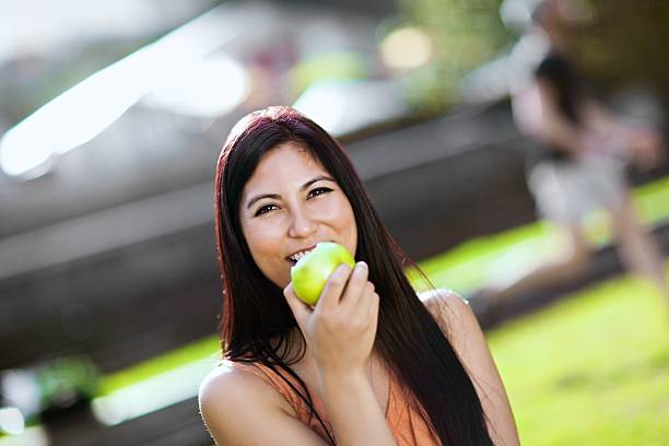 istock Young Woman Eating Apple Outside 164662225