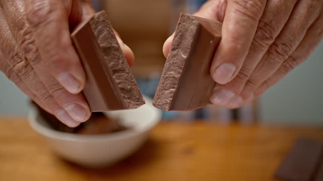SLO MO LD Male hands breaking a chocolate