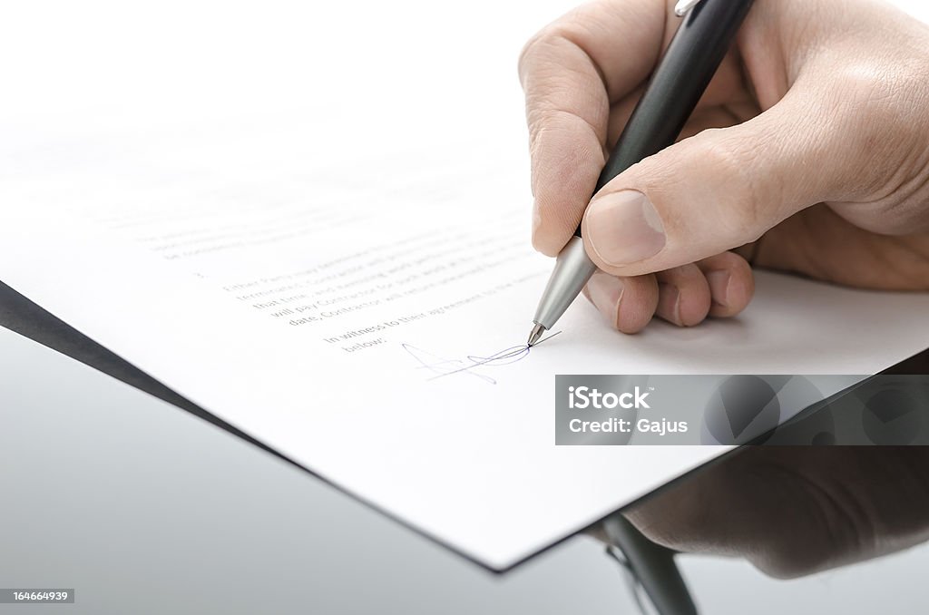 Maschio mano firma di un contratto su un tavolo nero - Foto stock royalty-free di Documento